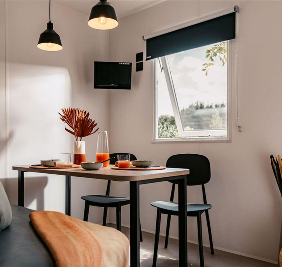 Eetkamer met bank en tafel in een 5-sterren IRM-cottage - Camping pomme de pin